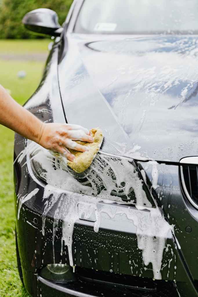 person cleaning a black car